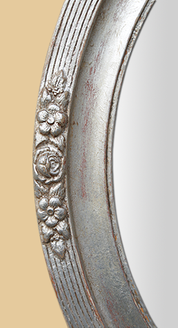 Détail miroir ovale argent patiné décor floral