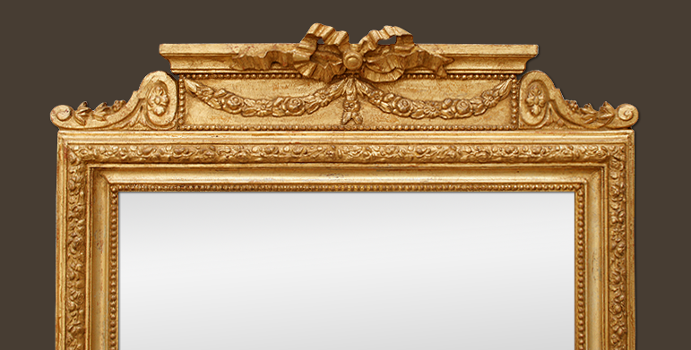 Galce miroir cheminée bois doré patiné à décor style Louis XVI, rubans et fleurs